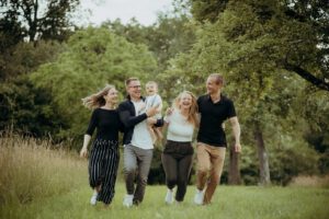 Familie läuft lachend über eine Wiese bei einem Outdoor Familienshooting nahe Stuttgart