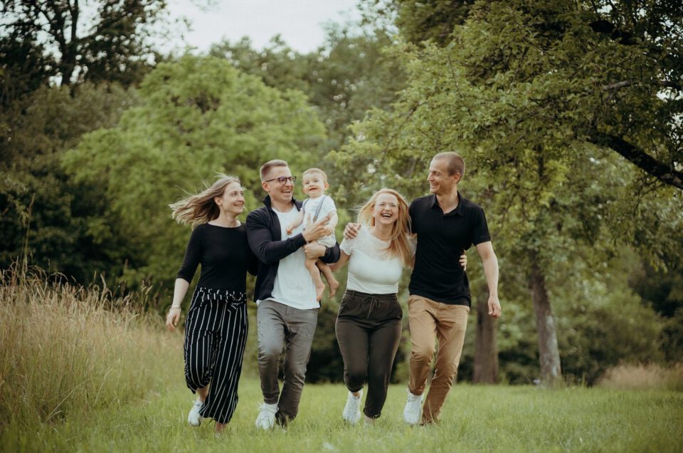 Familie läuft lachend über eine Wiese bei einem Outdoor Familienshooting nahe Stuttgart