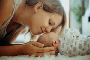 Familienfoto mit Mutter und Baby beim Neugeborenenshooting im Fotostudio bei Stuttgart